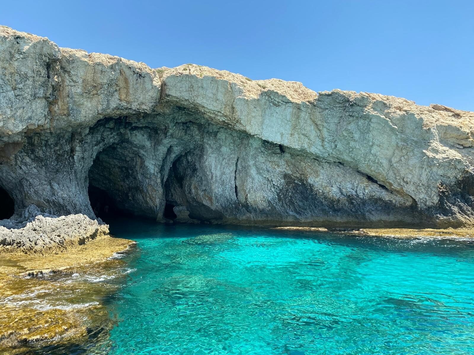 Explore a natural sea cave on Mallorca's coast, featuring clear turquoise waters and rugged rock formations.