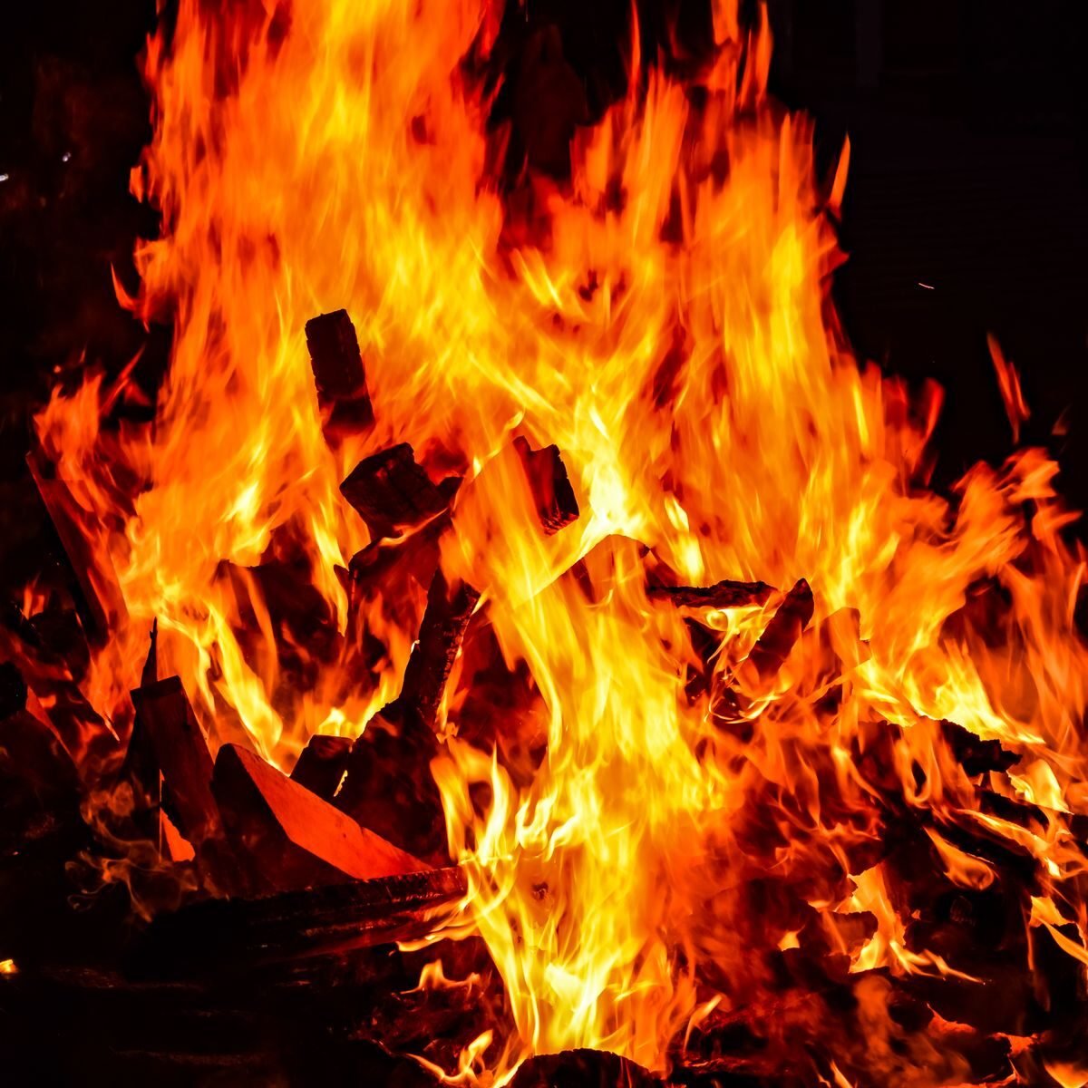 Close-up view of intense orange flames as wood burns, creating a warm and dynamic scene.