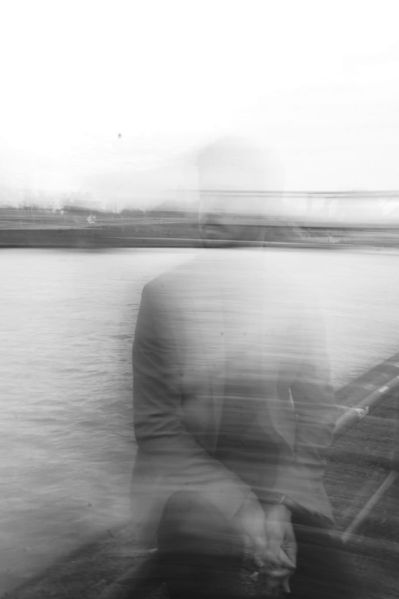 Ethereal black and white blurred shot of a man by a river.