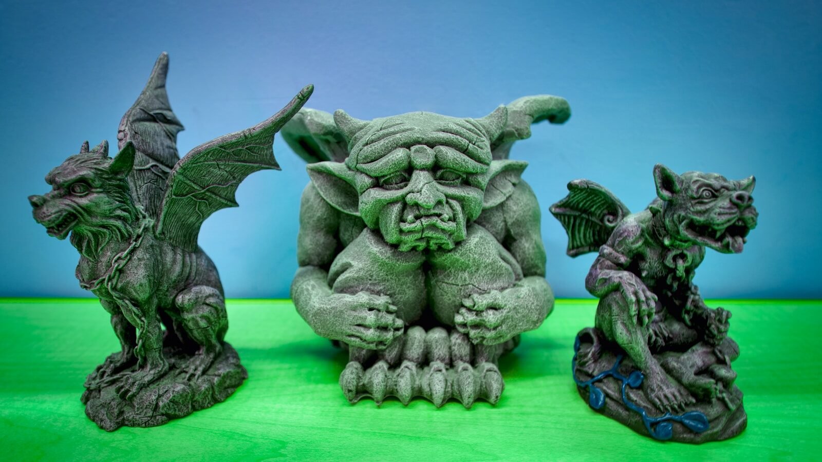 a group of three gargoons sitting next to each other