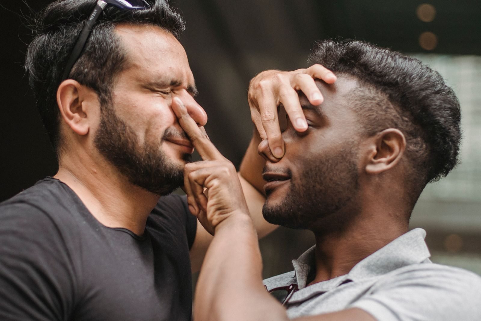 Close-up of two men playfully interacting, showcasing friendship and joy.