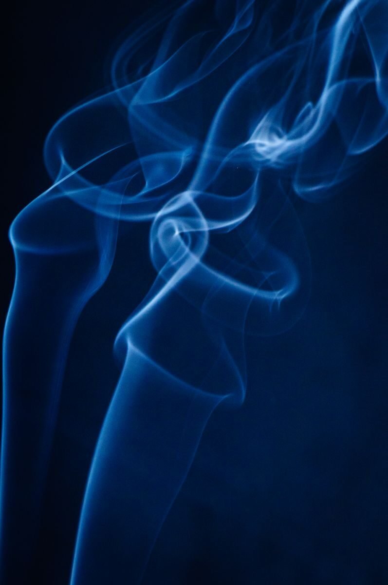 Beautiful abstract blue smoke swirling against a dark background, creating an artistic and mysterious effect.