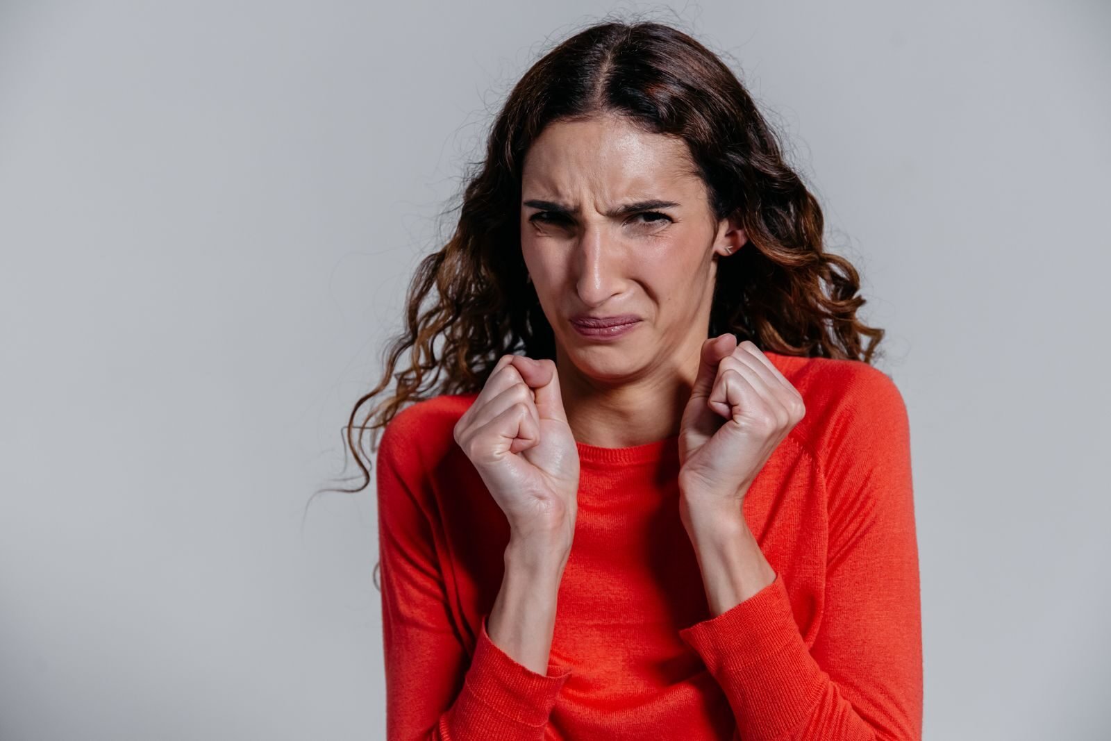 A woman displaying a disgusted facial expression indoors.