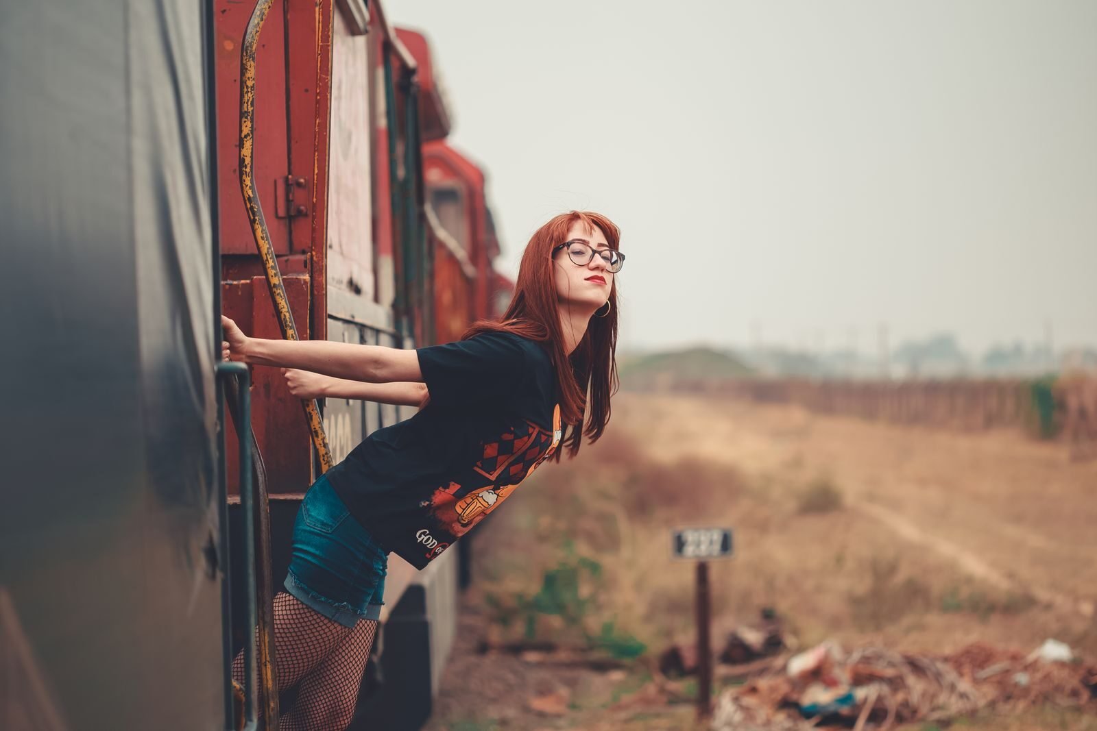 Young woman on train enjoying landscape view in Birigui, Brazil.